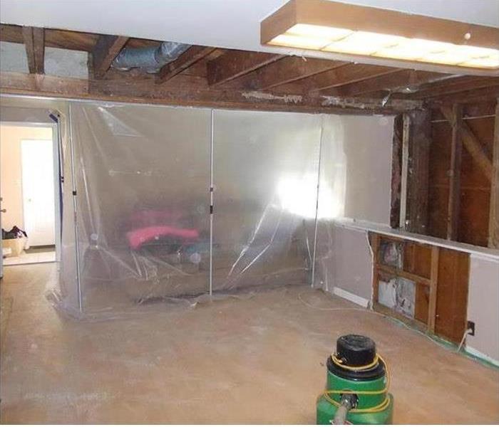 exposed ceiling joists and wall, poly containment bare floor