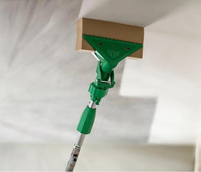 sponge removing soot damage from a ceiling