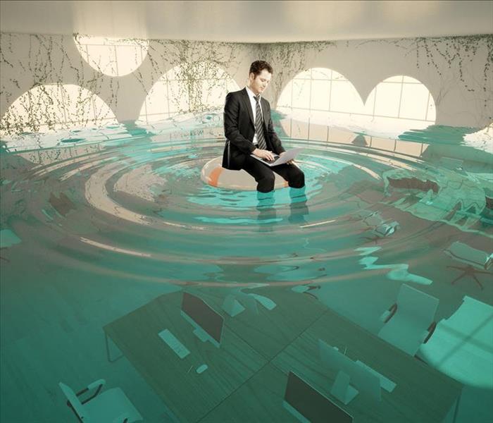 business suit sitting on flooded office with laptop