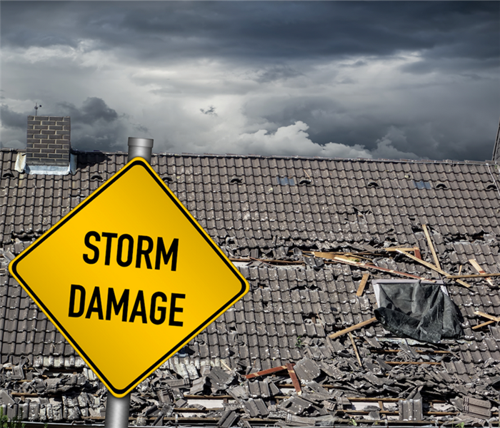 a storm damaged house with a yellow storm damage sign in front of it